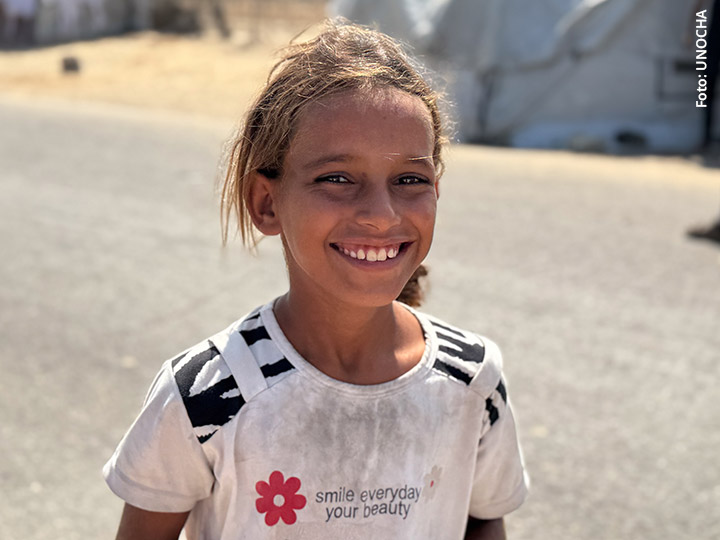 Das Cover der Zeitschrift "Im Lande der Bibel" (2/2026) zeigt ein lächelndes Mädchen aus Gaza. Foto: UNOCHA