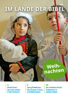 Zeitschrift Im Lande der Bibel 3/2025: Weihnachten. Das Cover zeigt zwei Kinder bei der Probe eines Krippenspiels. Das Mädchen mit traditionellem Kleid, Schleier und einem stilisierten Christuskind im Arm. Der Junge trägt ein weißes Gewand und hält einen roten Stab.