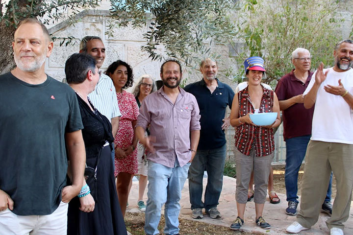 Mitarbeitende von Rabbis for Human Rights stehen lächelnd in einem begrünten Hof